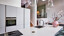 Schlichte grifflose Inselküche in Mattweiß mit weißer Arbeitsplatte in Marmoroptik von Ekelhoff Küchen in Nordhorn.