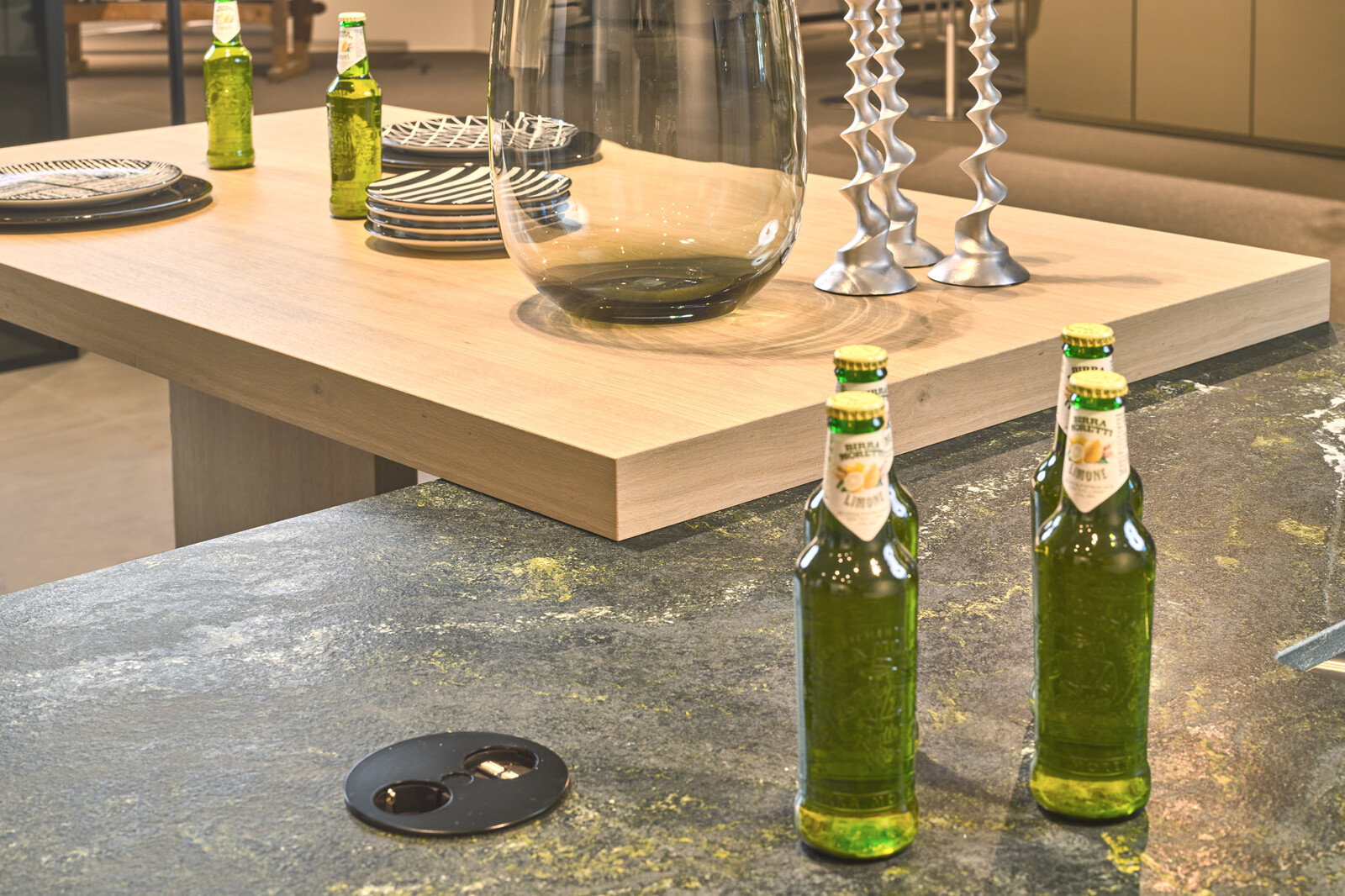 Showroomkeuken: next125 designkeuken met groen granieten keukenblad en houten bartafel