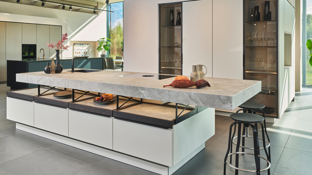 Schöne Designküche Poggenpohl PlusModo mit besonderer Kücheninsel. Diese luxuriöse Ausstellungsküche ist jetzt stark rabattiert. Zu sehen bei Ekelhoff Küchen in Nordhorn