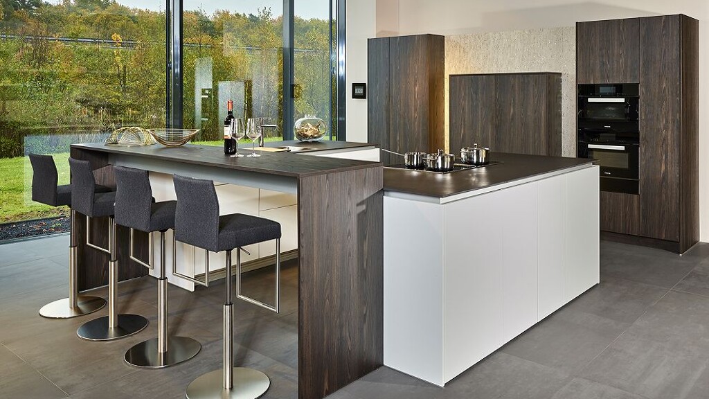 Bijzondere Poggenpohl Segmento keuken met twee lichte eilanden, aangehangen bar met barkrukken en bruine kasten