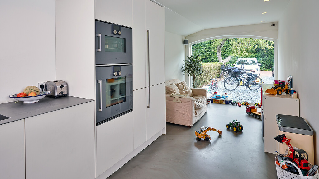 Grifflose U-Küche in Magnolie mit Edelstahl-Arbeitsplatte und Gaggenau-Geräten von Ekelhoff Küchen. Lesen Sie den Küchenbericht mit Fotos.