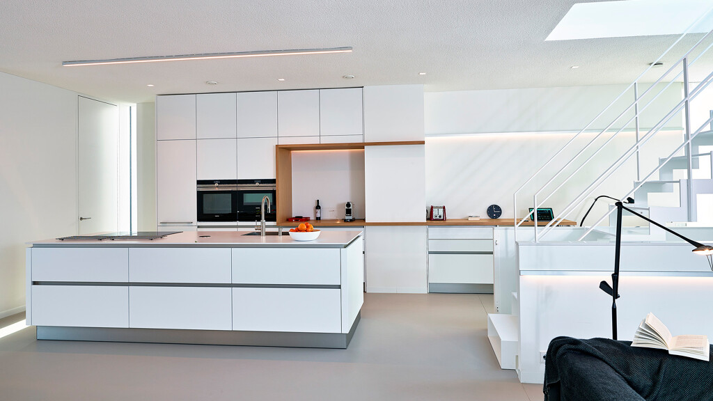 Grifflose Inselküche von Contur in weiße Satinlack mit Holzdetails. Ekelhoff-Küchen in Nordhorn.