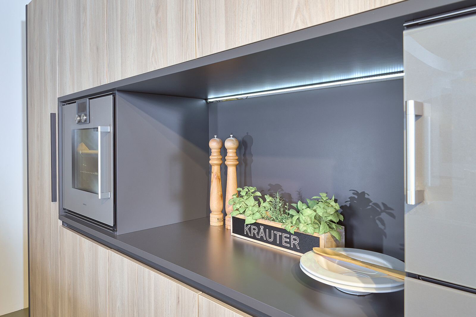 Showroomkeuken: eilandkeuken van Contur met houten kastenwand met nis