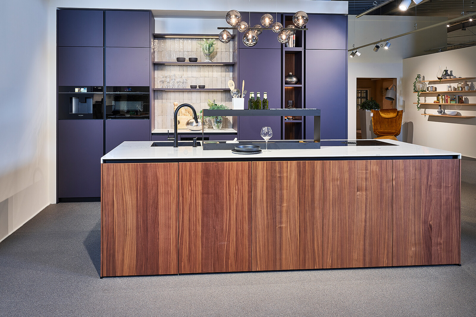 Designkeuken in Aubergine en notenhout van next125 met wit marmerlook blad