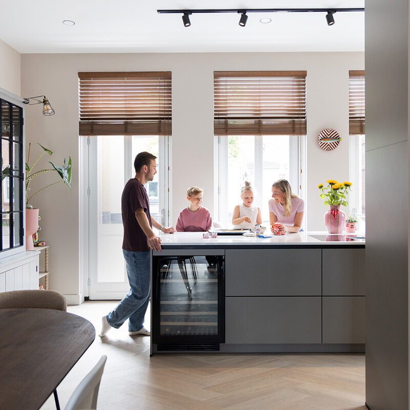 Grijze keuken met kookeiland, zwarte details en composiet marmerlook blad 
