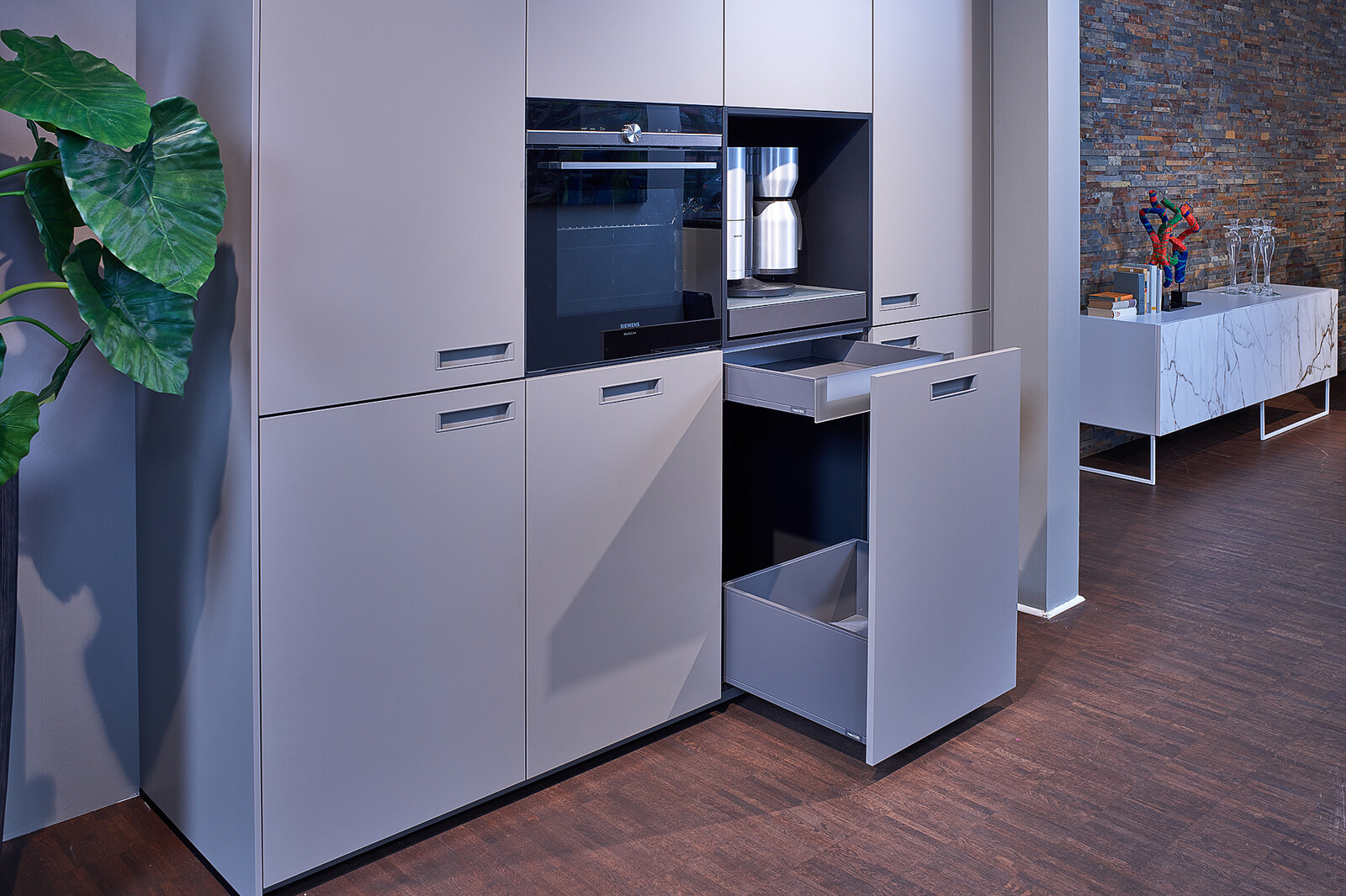 Showroomkeuken: next125 designkeuken met hoge kastenwand in Terragrijs