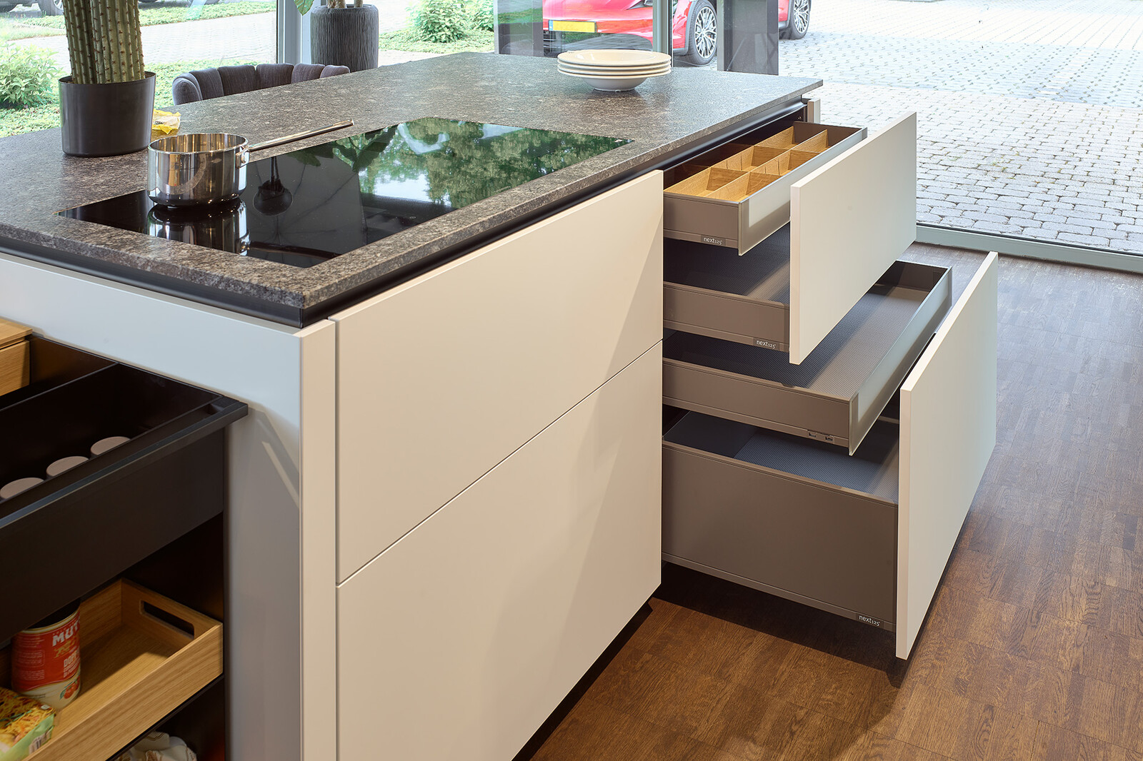 Showroomkeuken: grote next125 eilandkeuken in wit en grafietgrijs eiken met veel lades