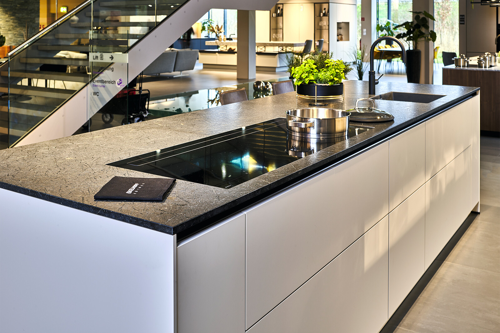 Showroomkeuken_next125 designkeuken met pocketdeuren en Black Ice graniet