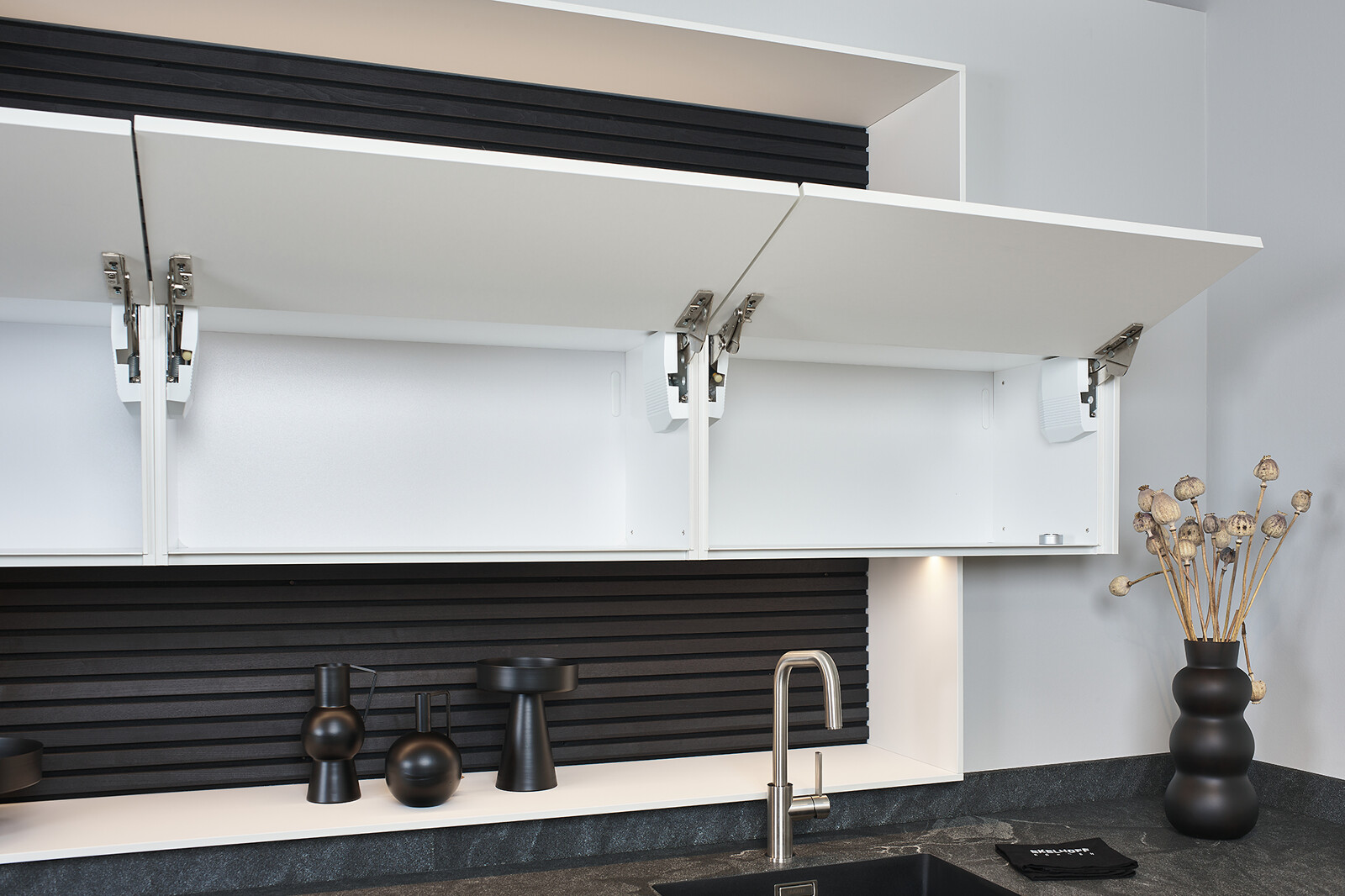 Showroomkeuken: SieMatic Mondial in lotuswit met schiereiland, granieten blad en nis met bovenkastjes- Ekelhoff Keukens