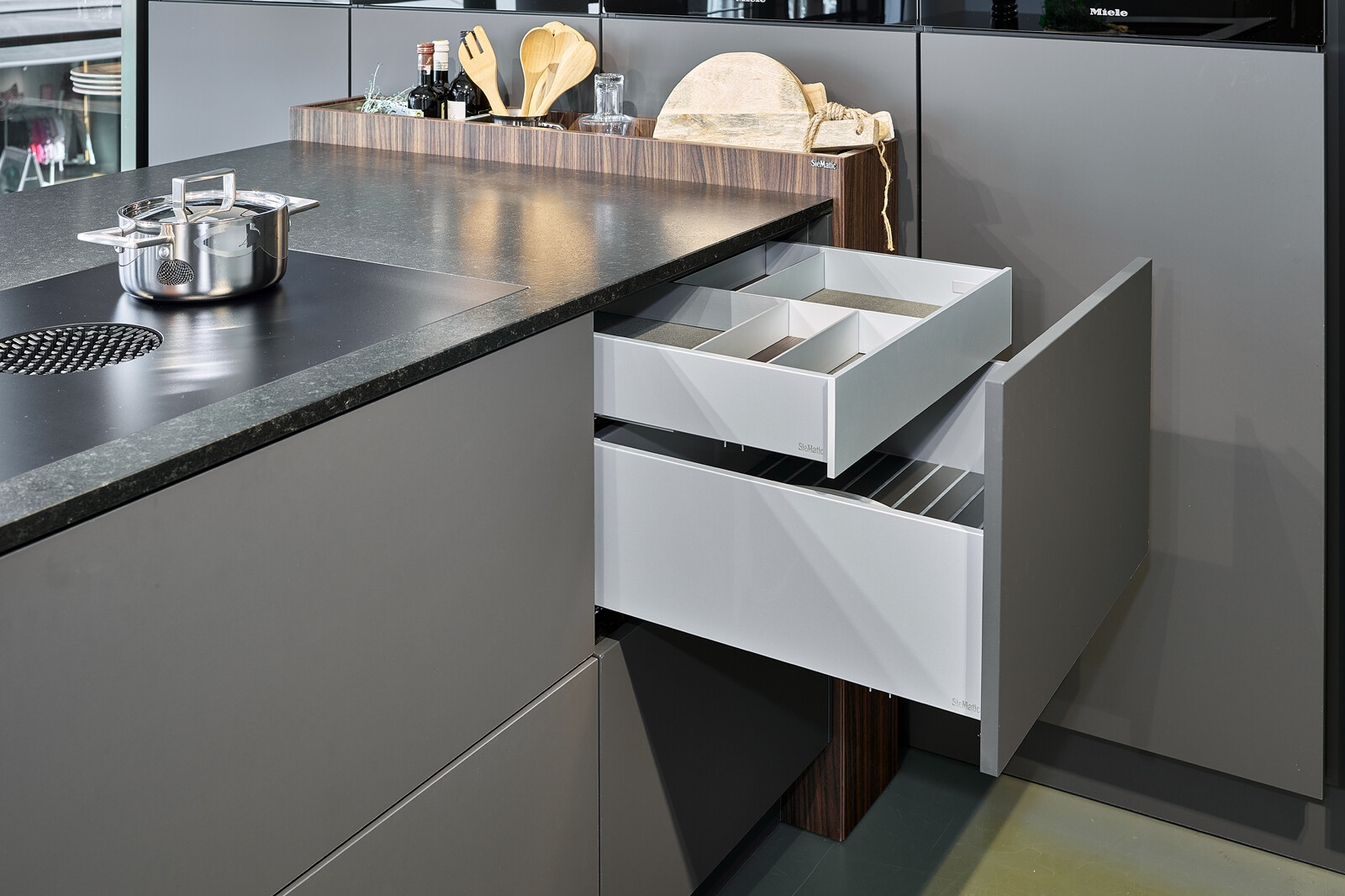 Showroomkeuken: SieMatic S2: grafietgrijze keuken met graniet keukenblad en notenhouten accenten