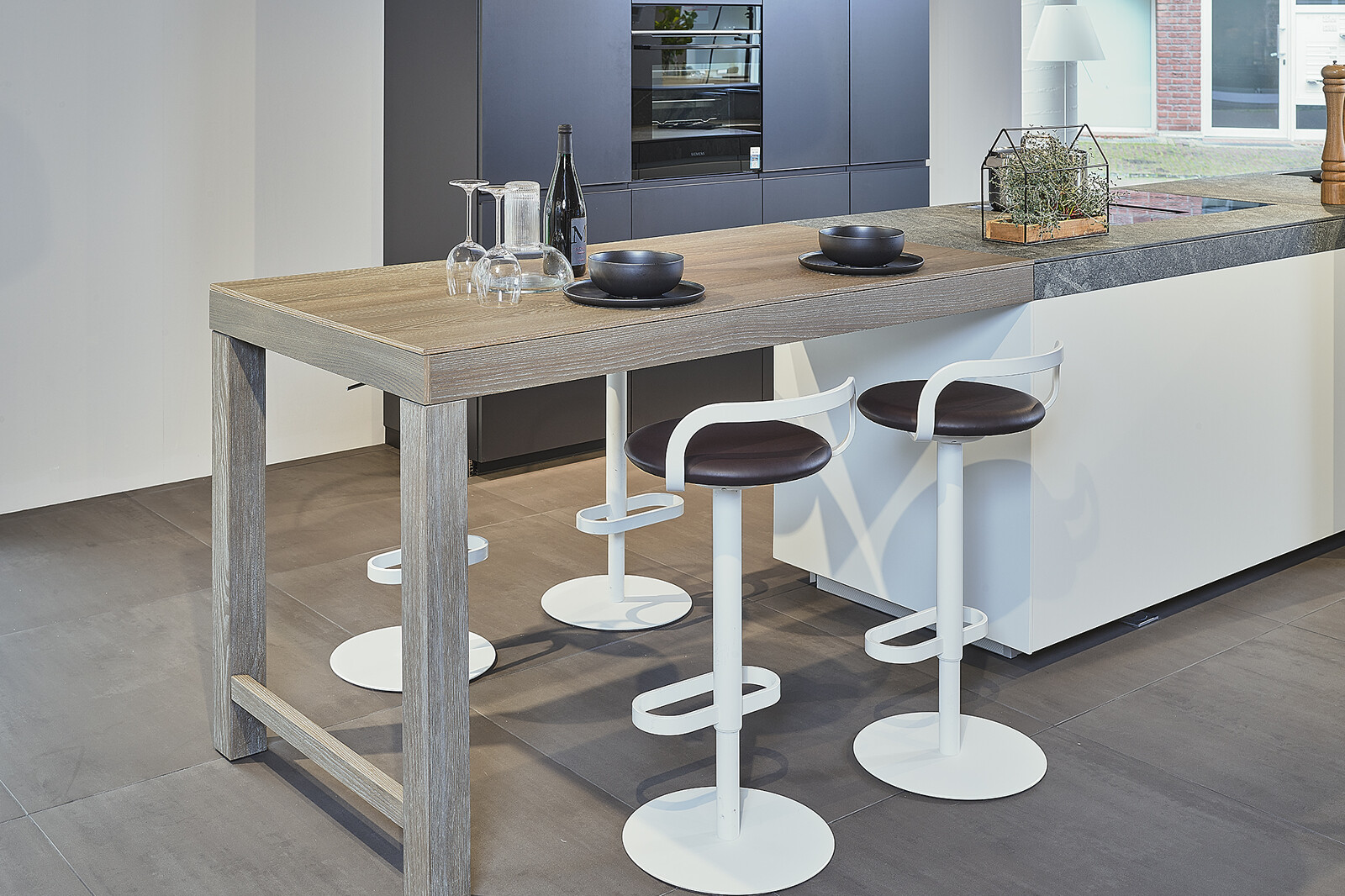 Showroomkeuken: Valcucine designkeuken met eiland, granieten aanrechtblad en bartafel