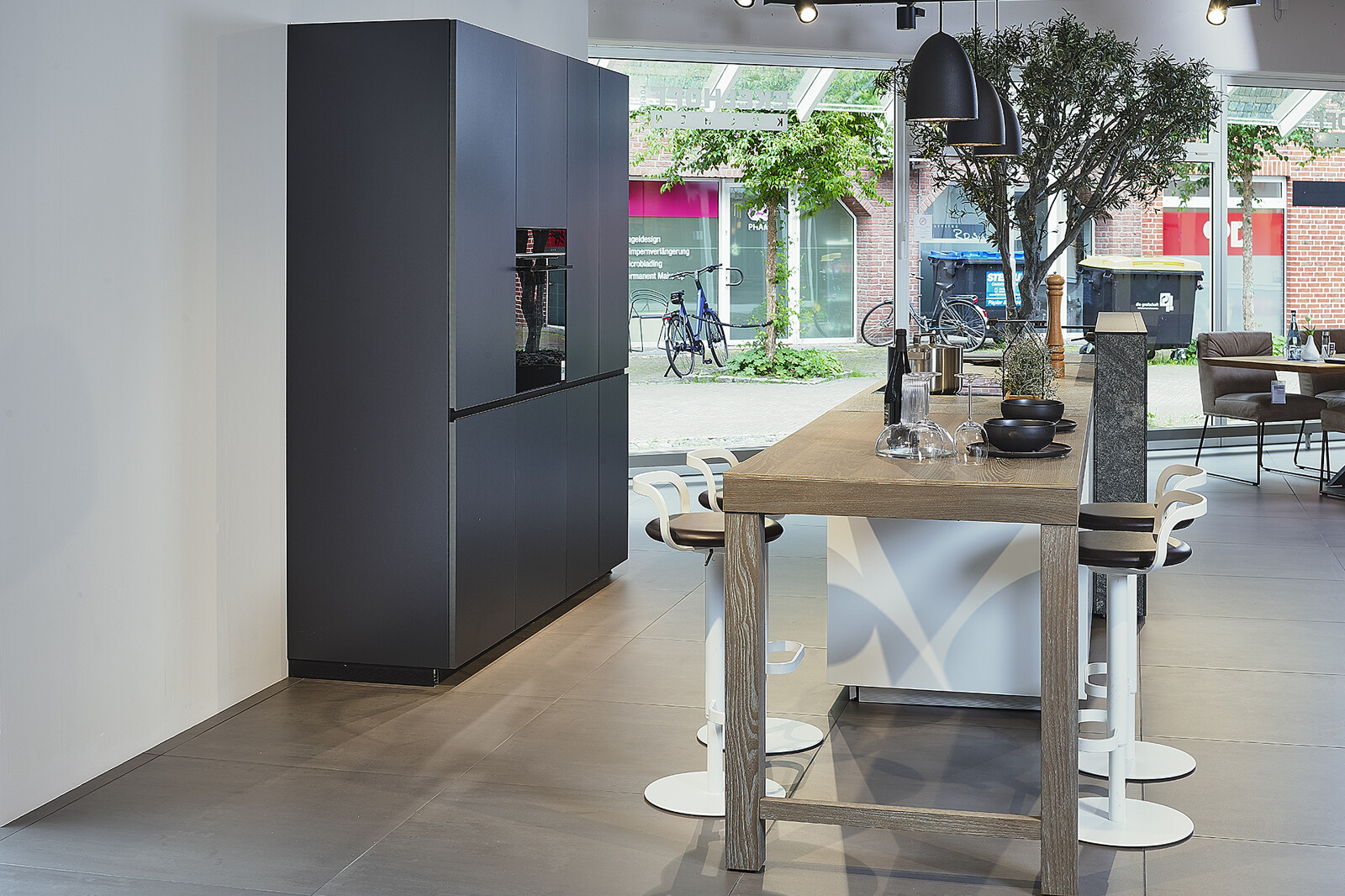 Showroomkeuken: Valcucine designkeuken met eiland, granieten keukenblad en bartafel