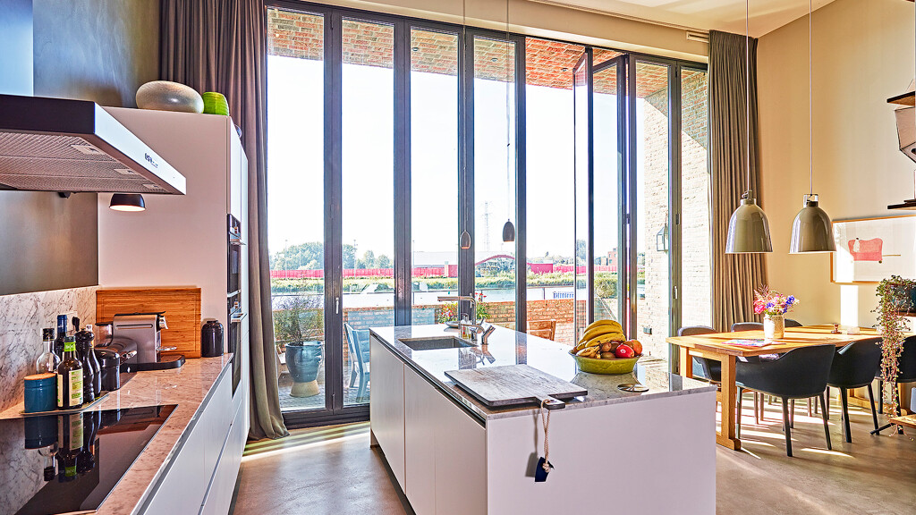 Grifflose weiße Küche von Contur mit Spülinsel und Arbeitsplatte und Rückwand aus Marmor. Realisiert in Amsterdam von Ekelhoff Küchen, Deutschland.