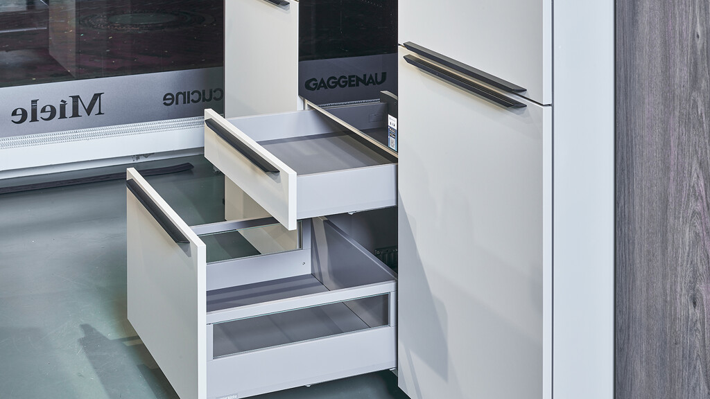 Aanbieding keuken: Stijlvolle eilandkeuken in kiezelgrijs en donker eiken (im.). Het werkblad is van keramiek in marmerlook, aan het eiland is plaats voor 2 barkrukken. Ontdek deze keuken bij Ekelhoff in Nordhorn.