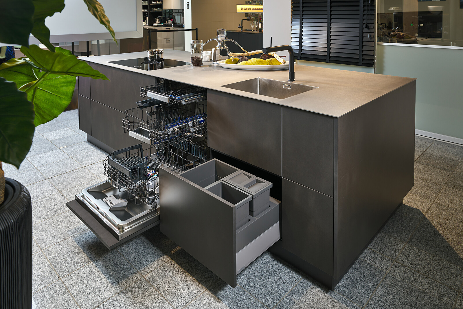 Showroomkeuken: Industriële eilandkeuken van Contur met rvs blad, staallook fronten en afvalsysteem in lade