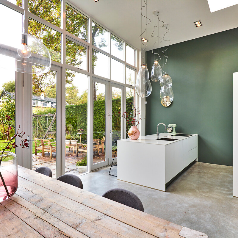 Schlichte grifflose Inselküche in Mattweiß mit weißer Arbeitsplatte in Marmoroptik von Ekelhoff Küchen, Nordhorn.