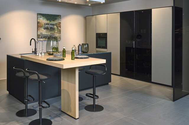 Showroomkeuken: next125 designkeuken met groen granieten aanrechtblad en bartafel