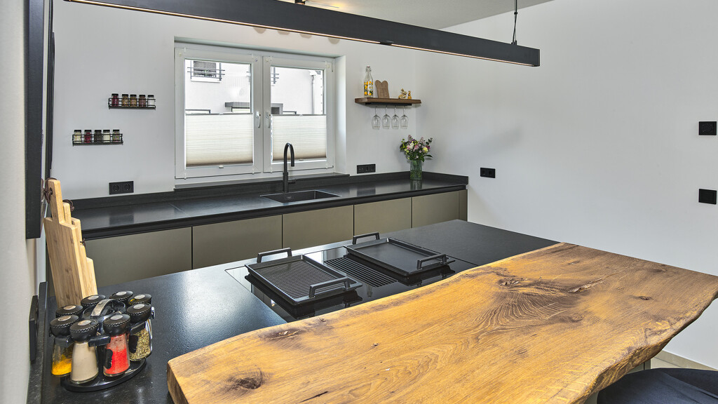 Kleine keuken van next125 met kookeilend, glasfronten en eikenhouten bar. Ontdek de keuken van keukenadviseur Benjamin Cicek van Ekelhoff Keukens