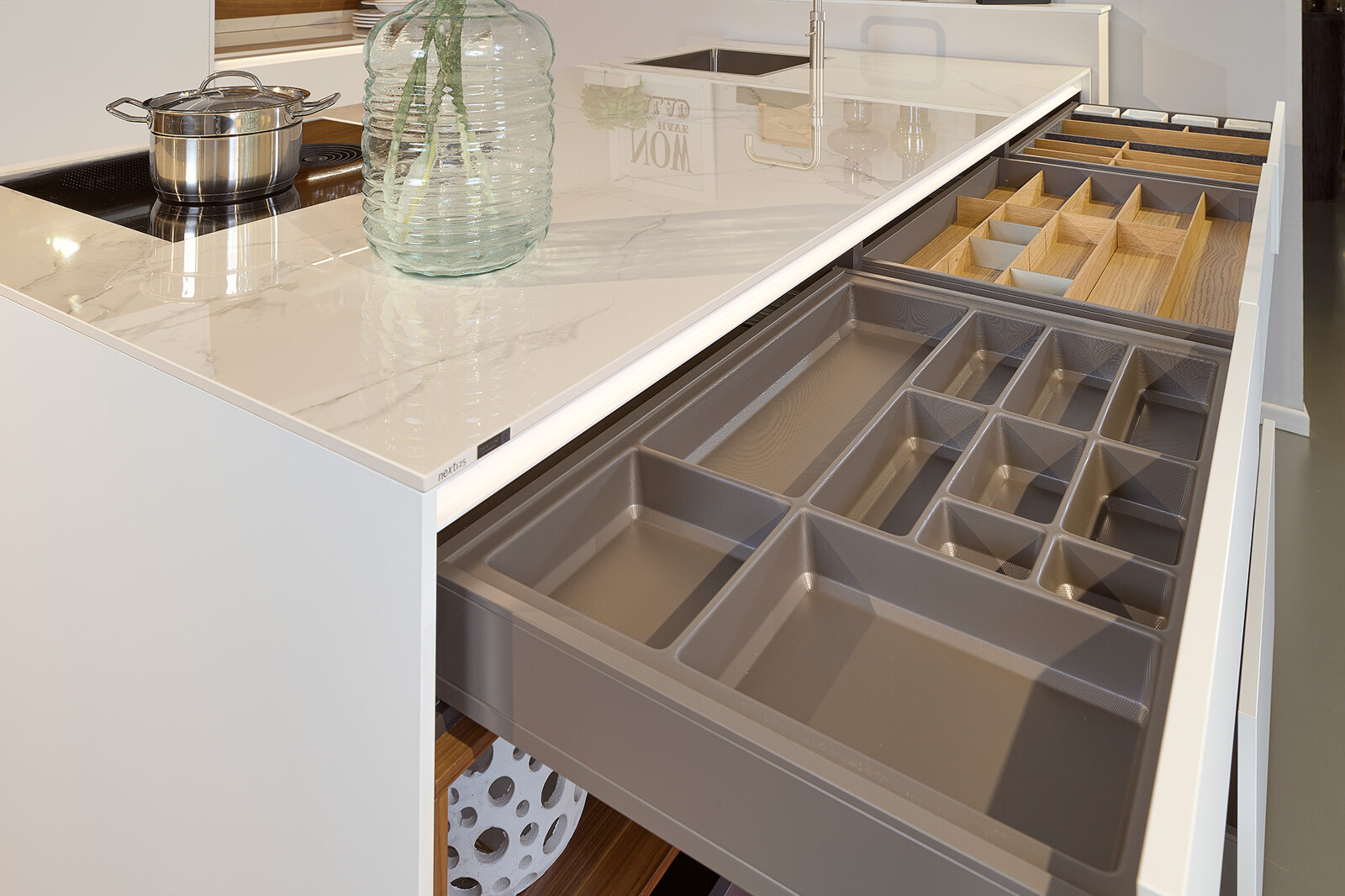 Showroomkeuken next125 - Witte eilandkeuken in fenix met notenhout en veel lades