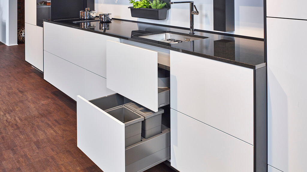 Keukennis met kook- en spoelgedeelte en geopende lades onder de spoelbak voor het afvalsysteem