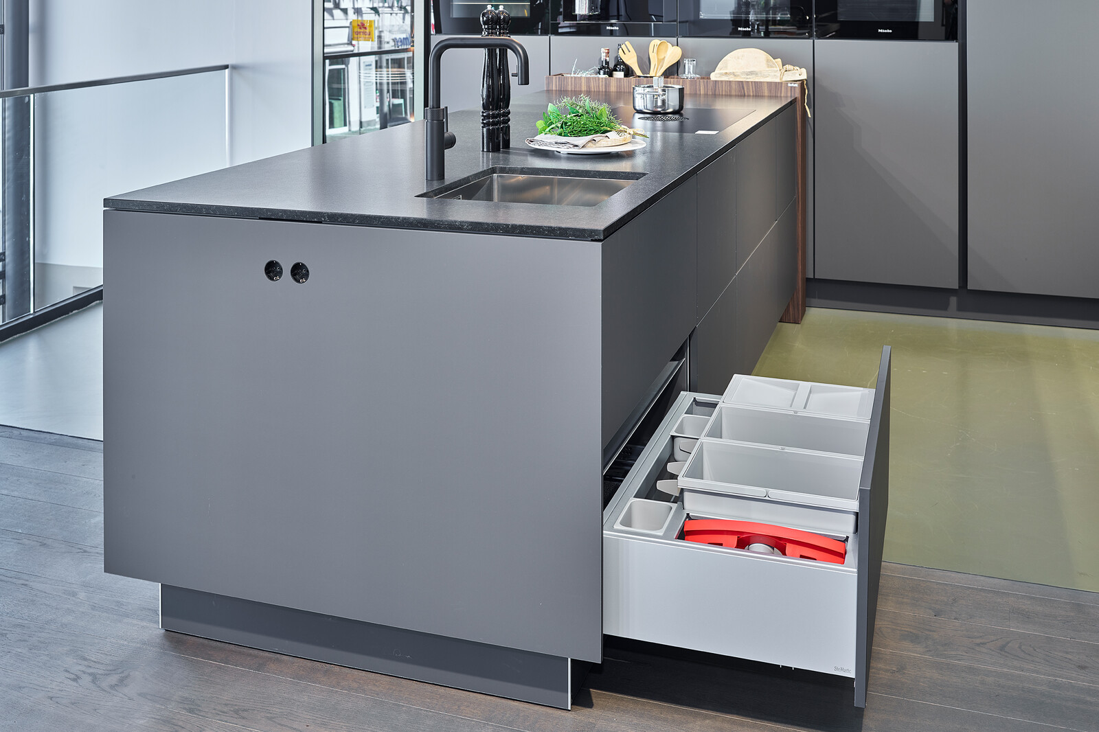 SieMatic Showroomkeuken in grafietgrijs met vitrinekasten granieten aanrechtblad en afvalsysteem