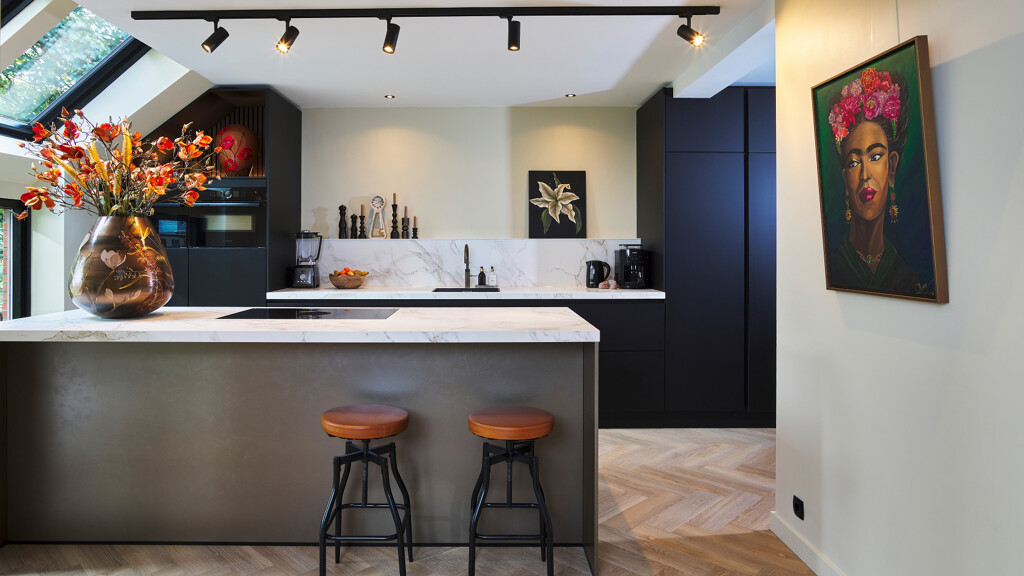 Zwarte Ballerina keuken met matte smartglas fronten en  keramiek werkblad van Dekton. Woonkeuken met kookeiland van vazen schilderes Margo Houwing