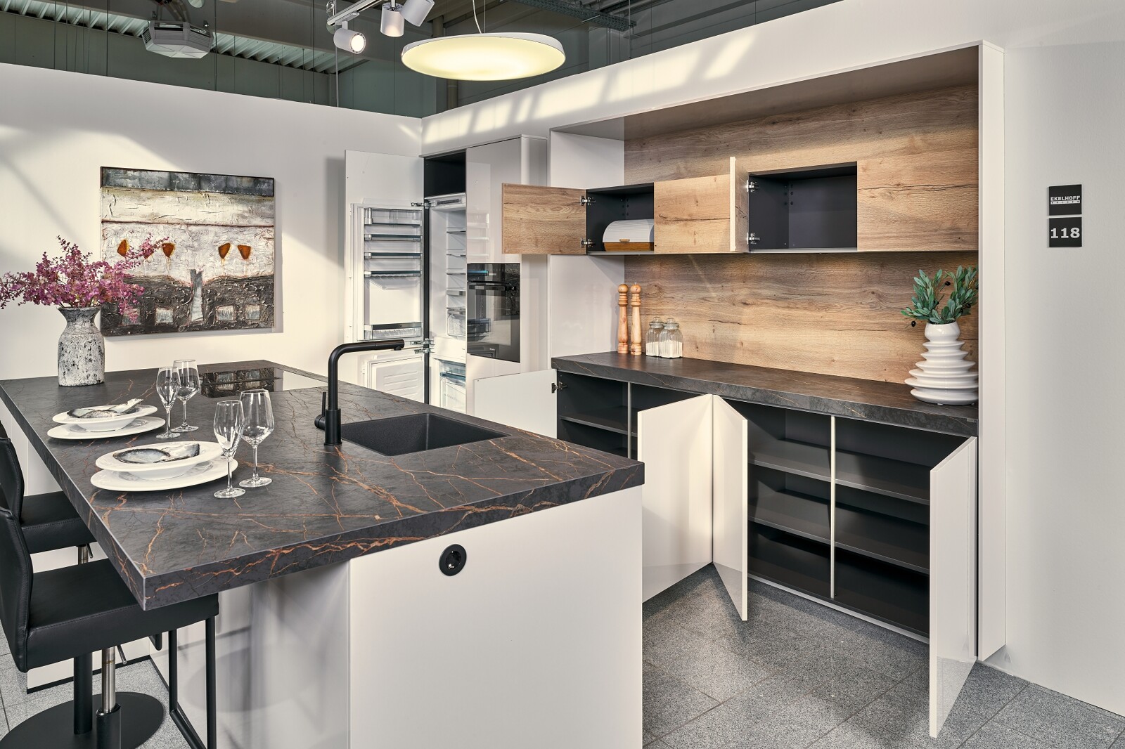 Showroomkeuken: eilandkeuken in hoogglans schelpwit met keramiek blad en houten details