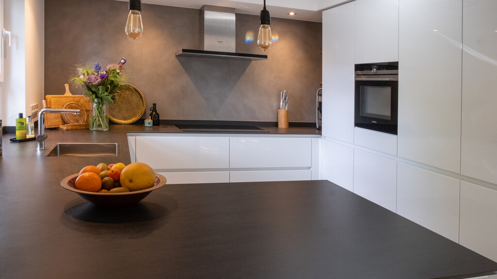 Contur Schüller in Kristallweiß hochglanz mit Keramik Arbeitsplatte.