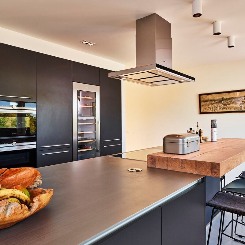 Schwarze Küche mit Edelstahl Arbeitsplatte. Contur Nova in matt Lavaschwarz. Realisiert durch Ekelhoff Küchen in Nordhorn