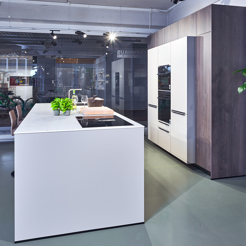 Contur Eilandkeuken in kiezelgrijs en donker eiken (im.). Het werkblad is van keramiek in marmerlook, aan het keukeneiland is plaats voor 2 barkrukken. incl kookplaat met afzuiging van Airo Design