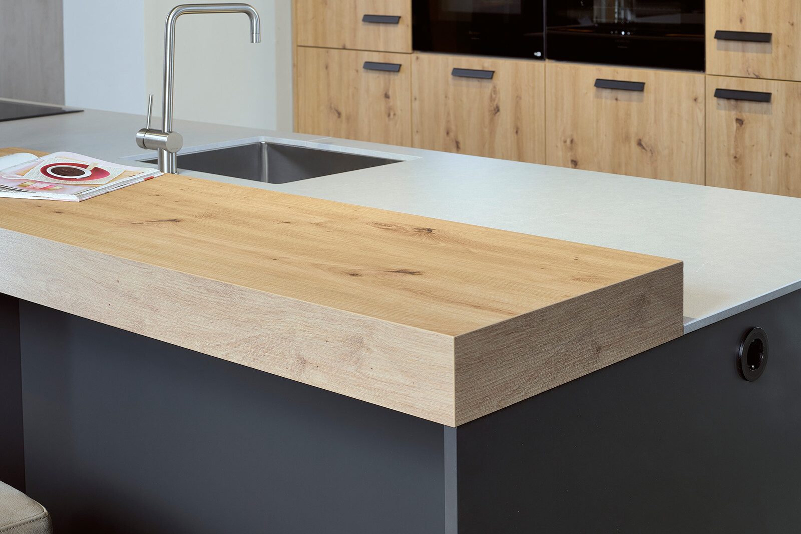 Showroomkeuken: Eilandkeuken met bar in matzwart en eikenlook
