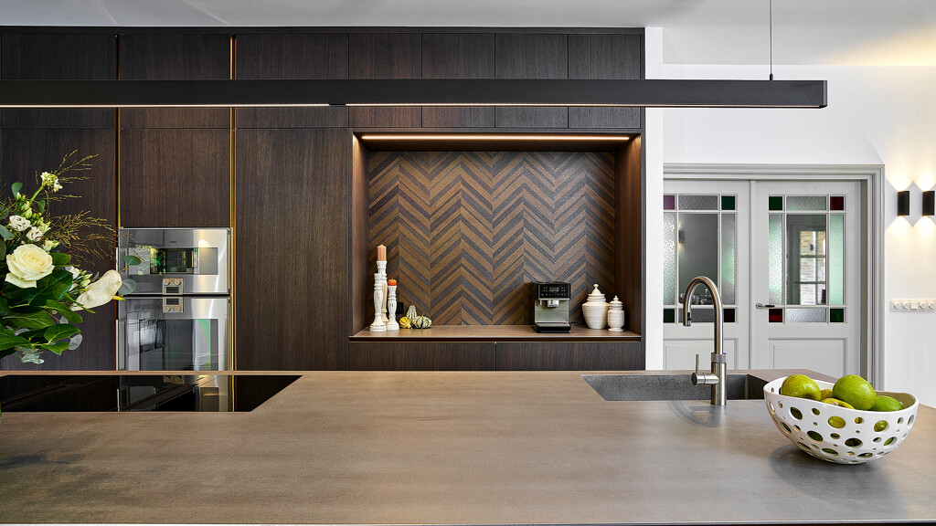 Wunderschöne SieMatic SLX Küche mit Oak Hazel Brown Fronten und Fischgrätfurnier an der Rückwand. Mit Küchenarbeitsplatte aus Edelstahl. Realisiert durch Ekelhoff Küchen.