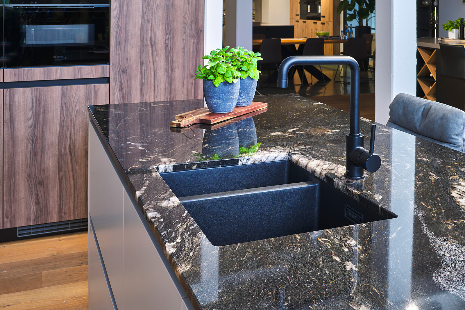 Showroomkeuken: Hoekkeuken met keukeneiland en Titanium Gold graniet keukenblad 