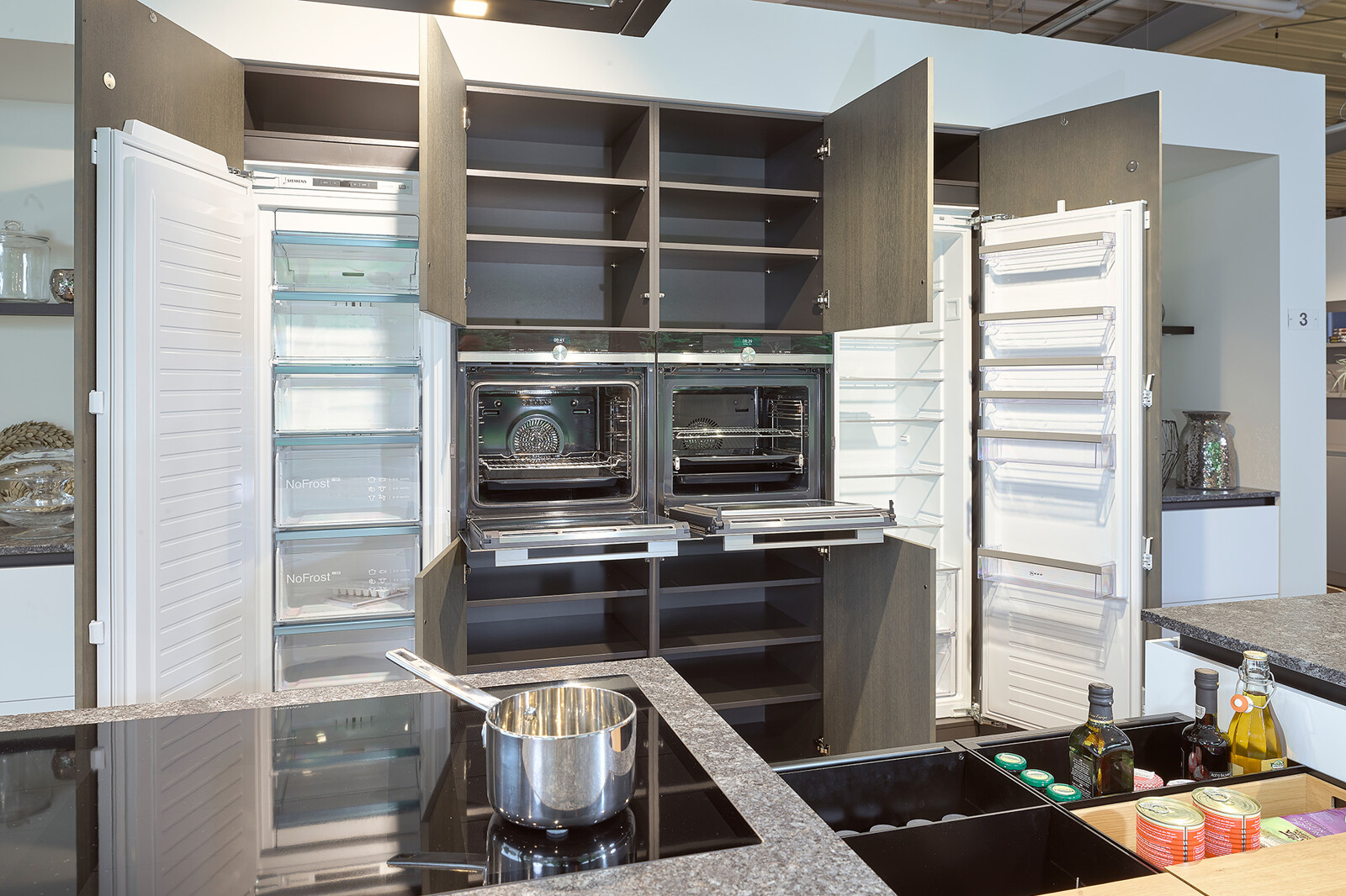 Showroomkeuken: grote next125 eilandkeuken in wit en grafietgrijs eiken met Siemens apparatuur