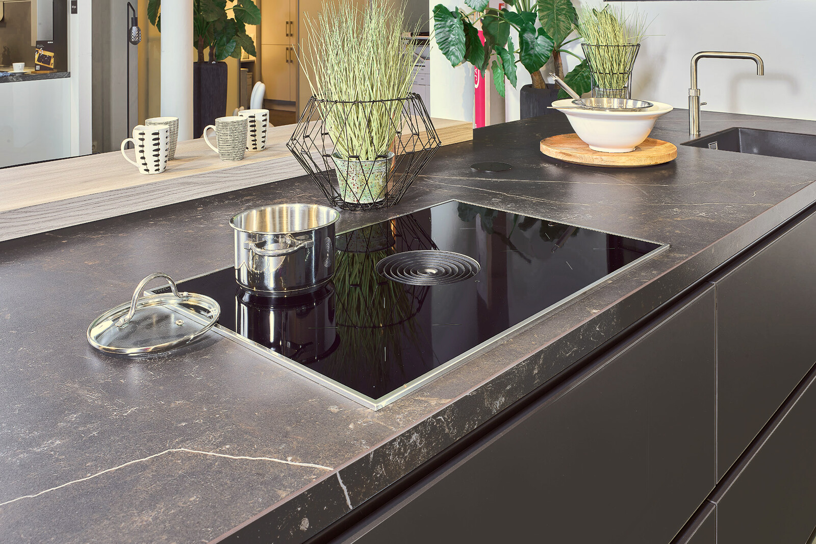 Showroomkeuken: Zwarte eilandkeuken met Dekton blad en Bora kookplaat