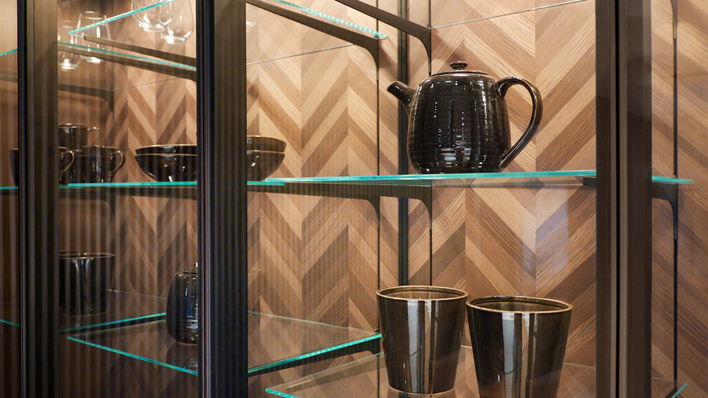 Detail der schönen SieMatic SLX-Vitrine mit Fischgrätfurnier-Rückwand. Zu sehen bei Ekelhoff Küchen in Nordhorn