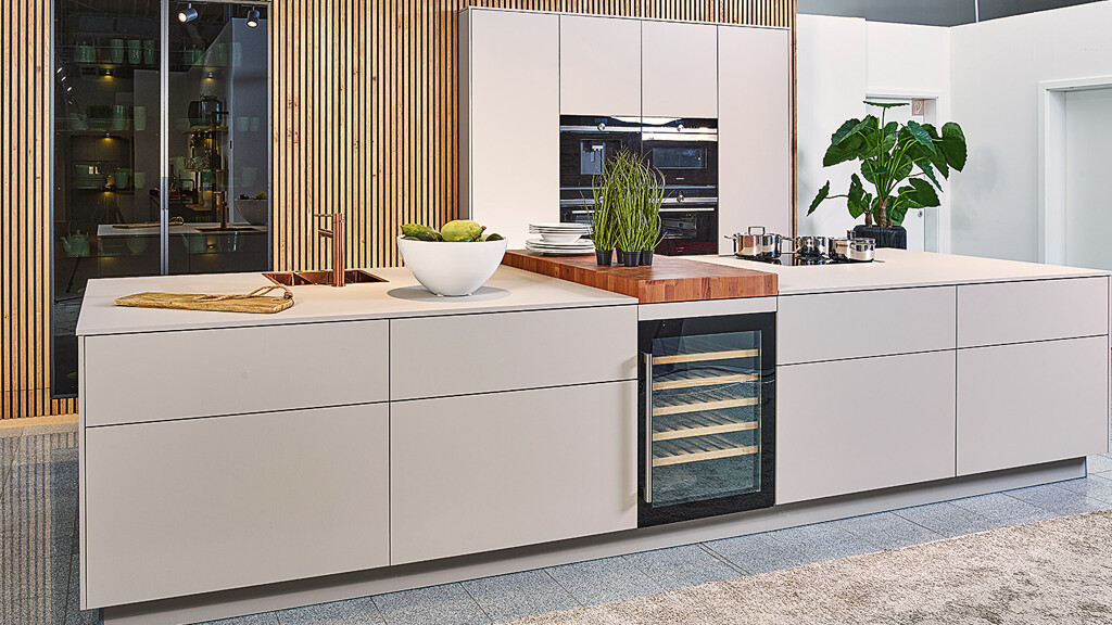 Ballerinakeuken met kookeiland en vitrinekasten in Resopal Pro Supermat Dark Powder. Bij Kuchenland Ekelhoff in Nordhorn