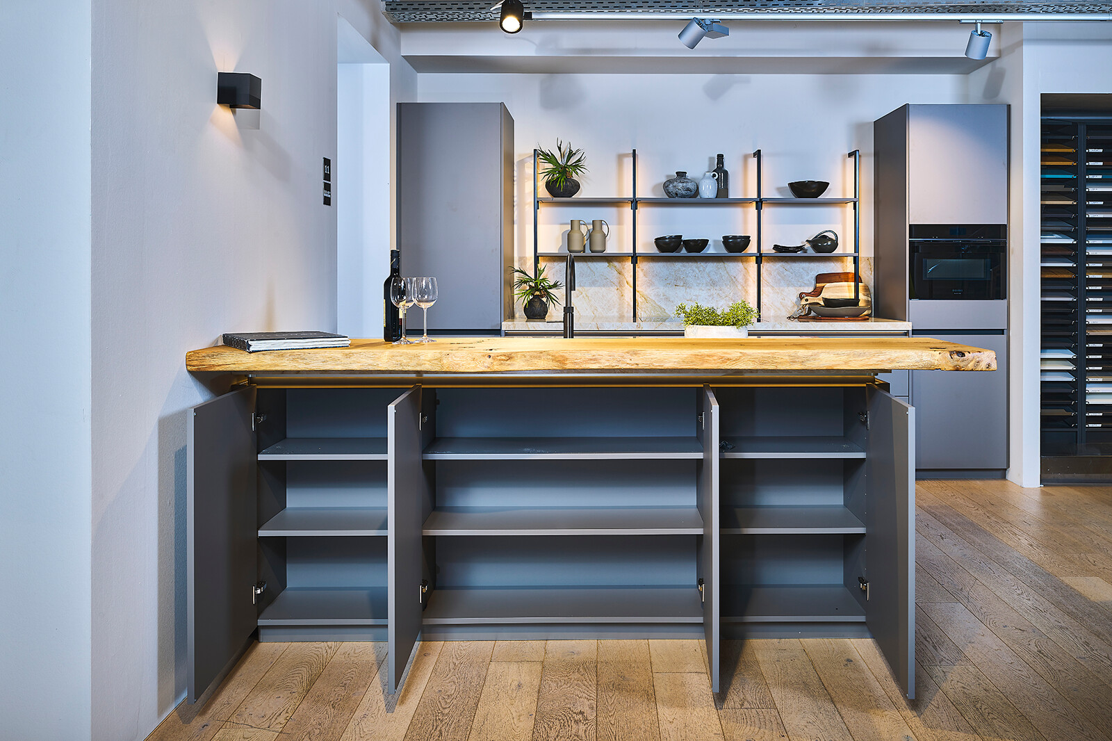 Showroomkeuken Ballerina: taupe eilandkeuken met houten bar met boomkant en glanzend keramiek blad - Ekelhoff