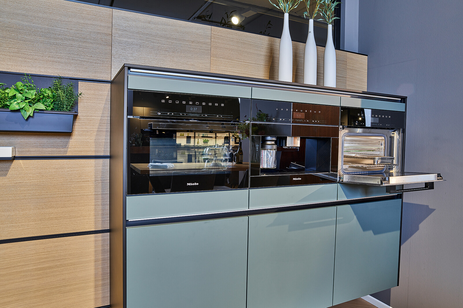 Showroomkeuken: Groene hoekkeuken met licht eiken van next125 - designkeuken met cube achterwand en miele apparatuur