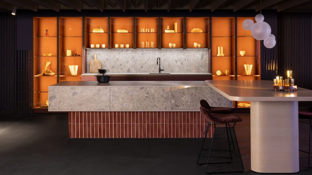 Poggenpohl vitrine keukenkasten met een oranje achterwand, glazen legplanken en LED verlichting. Ontdek Poggenpohl bij Ekelhoff Keukens in Nordhorn