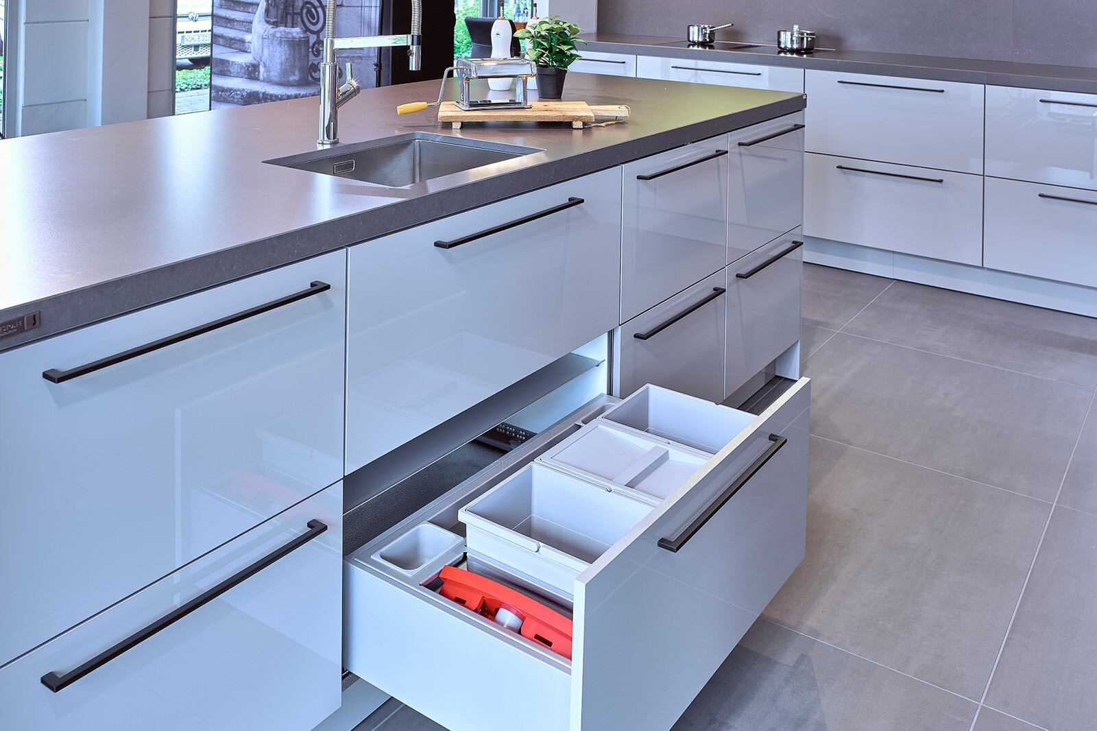 Showroomkeuken: SieMatic designkeuken met eiland in lichtgrijze similaque 