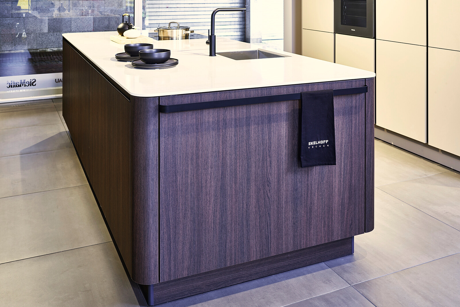 Showroomkeuken: SieMatic designkeuken, kookeiland met afgeronde hoeken - Ekelhoff Keukens