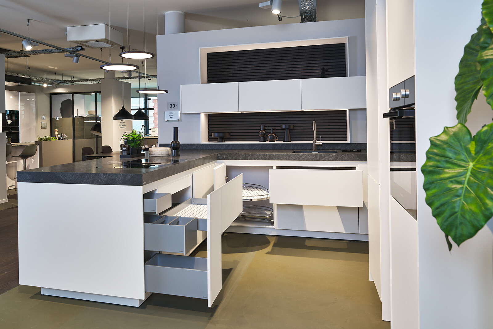 Showroomkeuken: SieMatic Mondial in lotuswit met schiereiland, granieten blad en veel lades- Ekelhoff Keukens Nordhorn