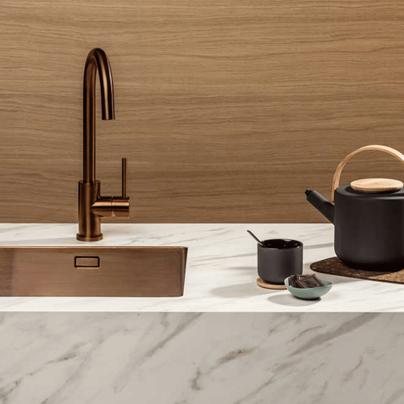 Helle Topcore Laminat Arbeitsplatte mit kupferner Spüle und Wasserhahn. Auch bei Ekelhoff Küchen in Nordhorn