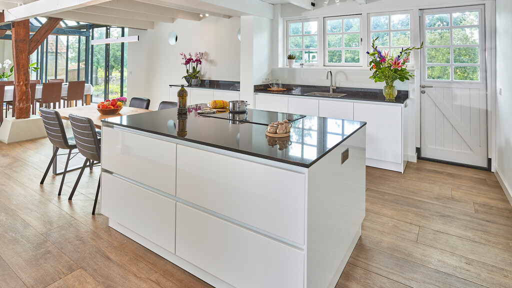 Skandinavische Küche mit weißen Hochglanzfronten von next125 und einer Küchenplatte aus Granit. Von Ekelhoff Küchen in Nordhorn.