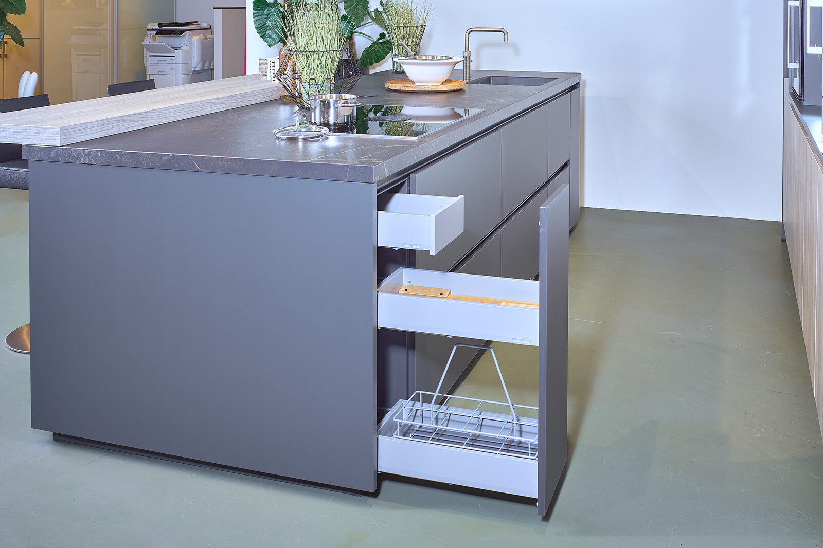 Showroomkeuken: zwarte eilandkeuken met houten kastenwand met veel praktische lades - Ekelhoff Keukens