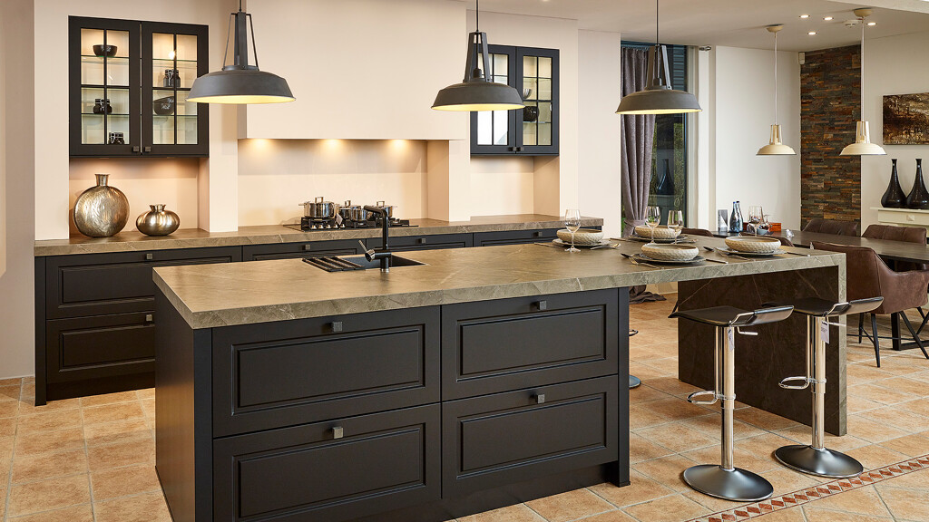 Schwarze Landhausküche von Contur mit Insel und angrenzendem Sitzbereich
