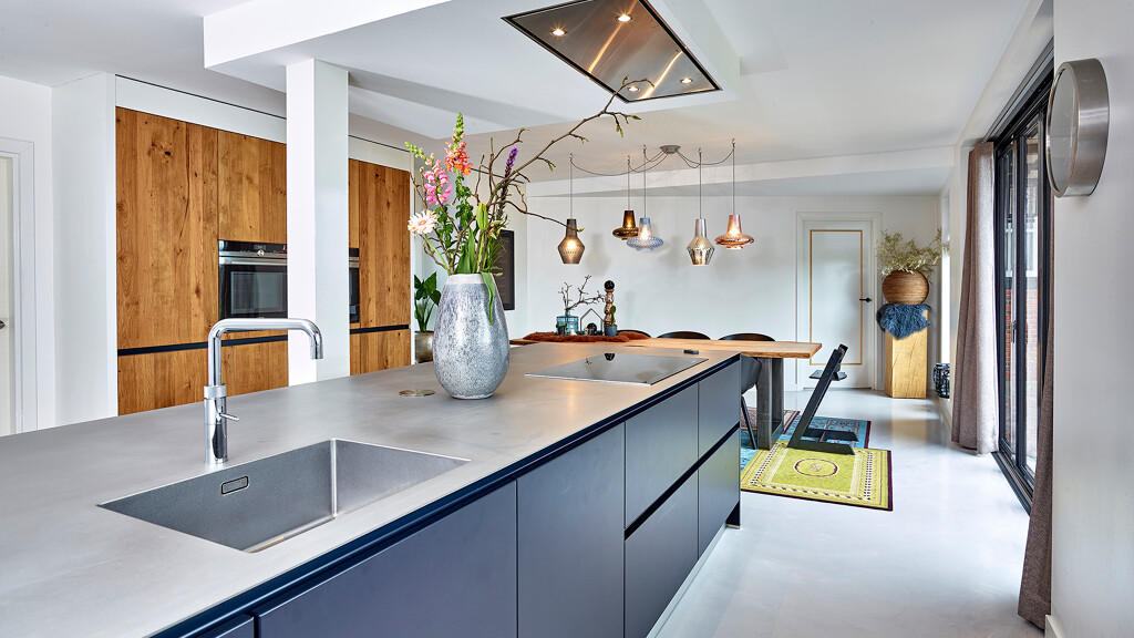 Inselküche in Indigoblau und Balkeneiche mit Edelstahl Arbeitsplatte. Realisiert durch Ekelhoff Küchen in Nordhorn