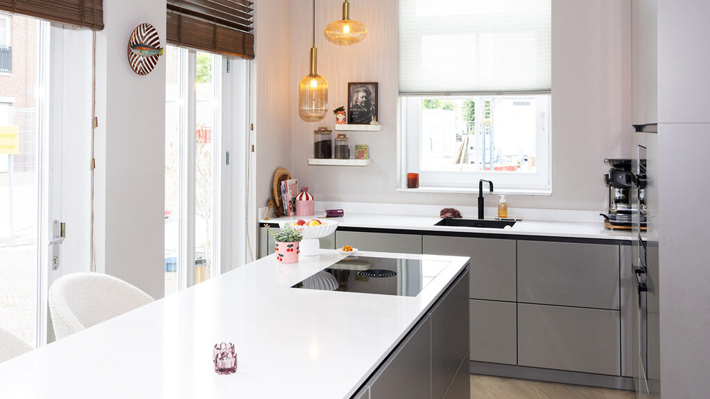Grijze keuken met kookeiland, zwarte details en marmerlook blad 