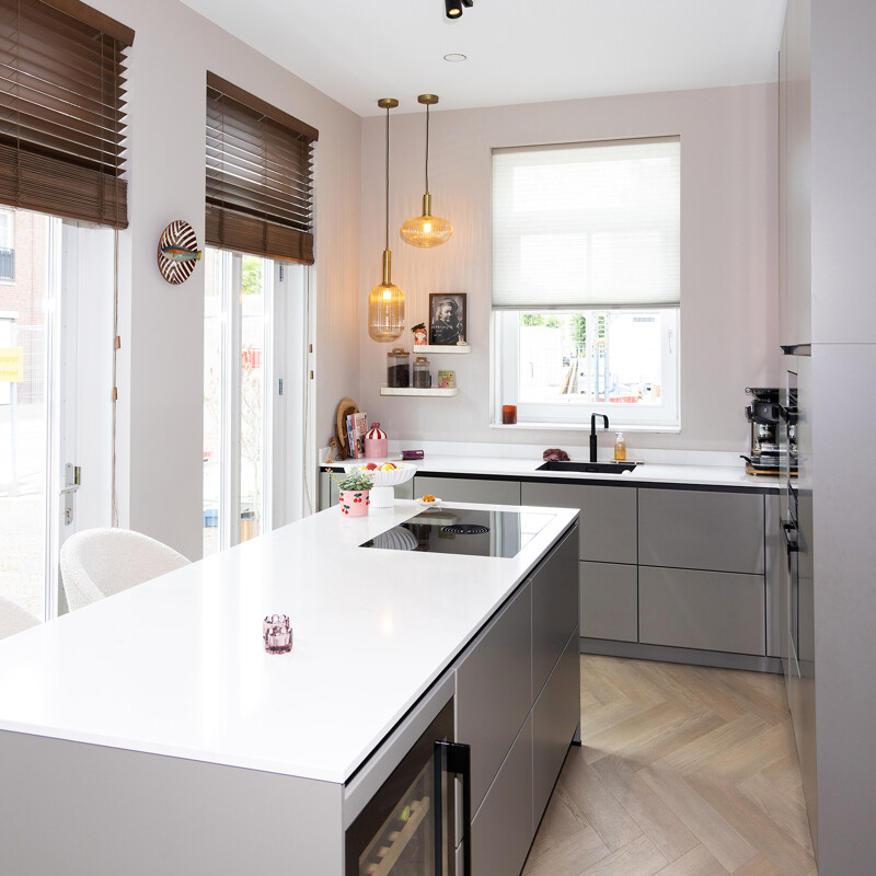 Grijze keuken met kookeiland, zwarte details en marmerlook blad 